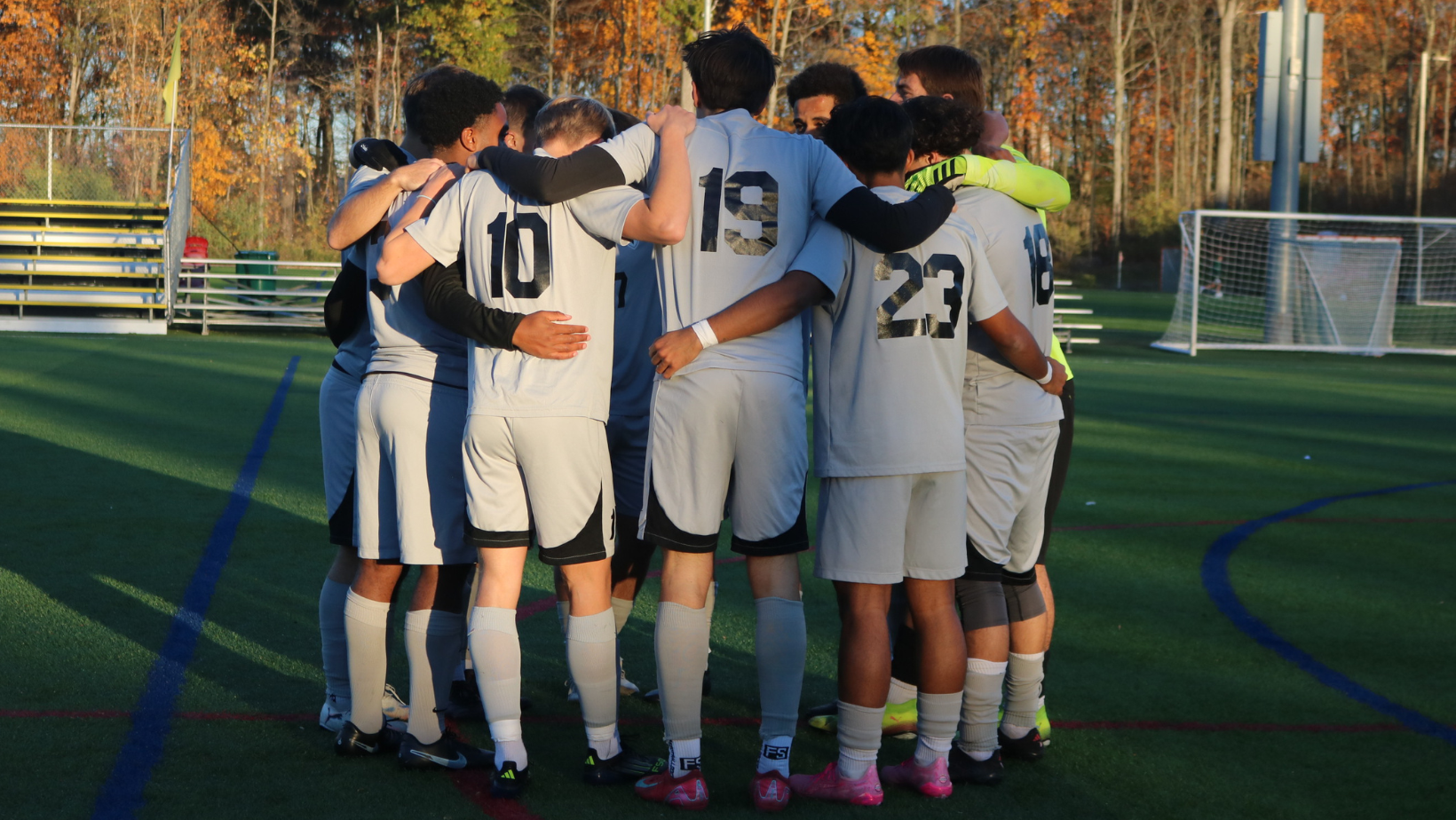 Men's Soccer players huddle before the start of the second half.